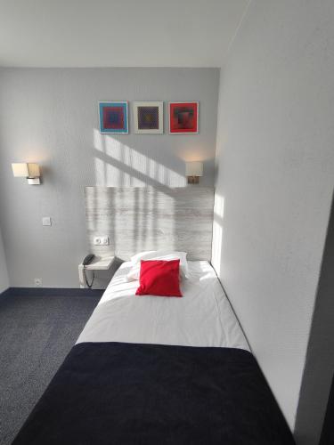 a bedroom with a red pillow on a bed at Campanile Grenoble Centre Gare in Grenoble