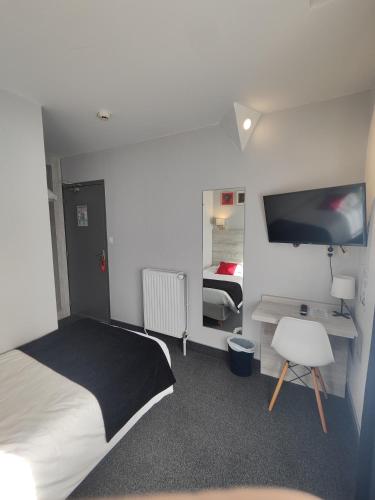 a bedroom with a bed and a desk and a tv at Campanile Grenoble Centre Gare in Grenoble