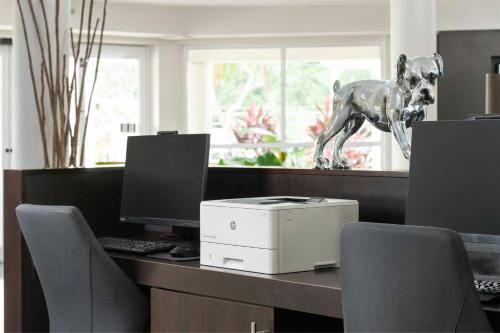 a desk with a computer and a statue of a dog on it at Courtyard by Marriott Key Largo in Key Largo