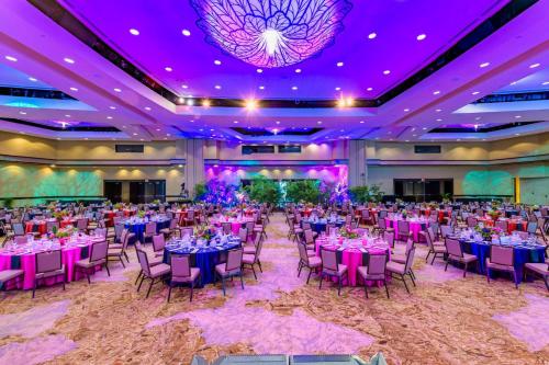 a ballroom with tables and chairs and purple lighting at Sheraton Waikiki Beach Resort in Honolulu