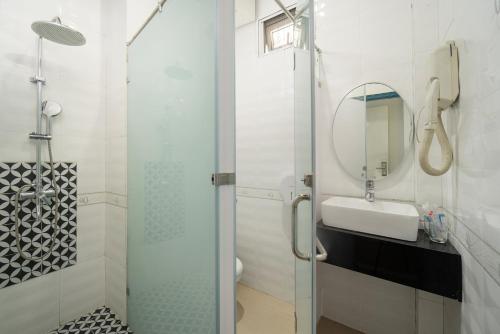 河内Hanoi Solo Hostel的浴室里有淋浴、洗手池和镜子。