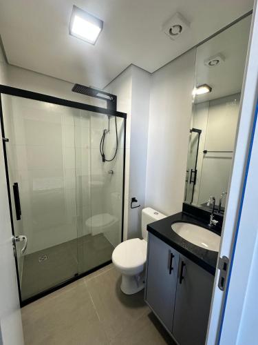 a bathroom with a shower and a toilet and a sink at Studio Cuiabá NOVO - Frente ao Shopping Estação in Cuiabá