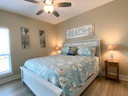 a bedroom with a bed and a ceiling fan at Fire and Ike - A stunning 4 bedroom, 3 bathroom, Beachfront Retreat! Massive Lot Packed w Amenities in Crystal Beach