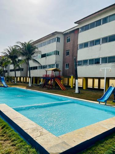 an empty swimming pool with a playground in front of a building at Kite house - prox do Cumbuco in Caucaia