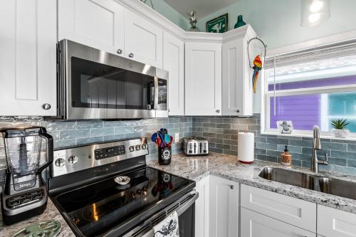 a kitchen with white cabinets and a stove top oven at Jolly Roger - Themed Beachfront 5BR with Arcade in Gilchrist