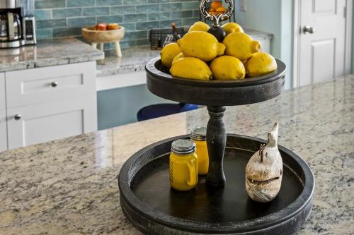 a table with a bowl of lemons on a stand in a kitchen at Jolly Roger - Themed Beachfront 5BR with Arcade in Gilchrist