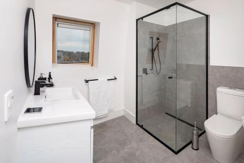 a bathroom with a shower and a sink and a toilet at Avonside Alpine Estate - Jindabyne in Coolamatong