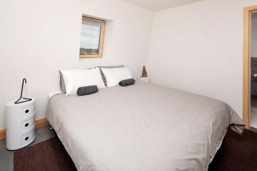 a white bedroom with a white bed and a window at Avonside Alpine Estate - Jindabyne in Coolamatong