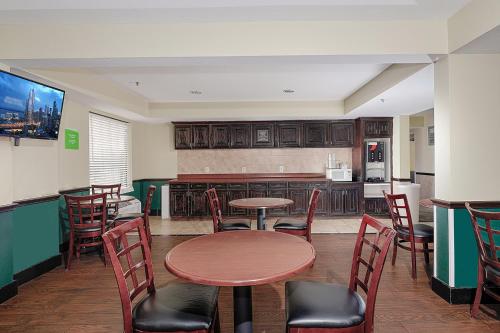 a restaurant with tables and chairs and a kitchen at GreenTree Inn - IAH Airport JFK Blvd in Houston