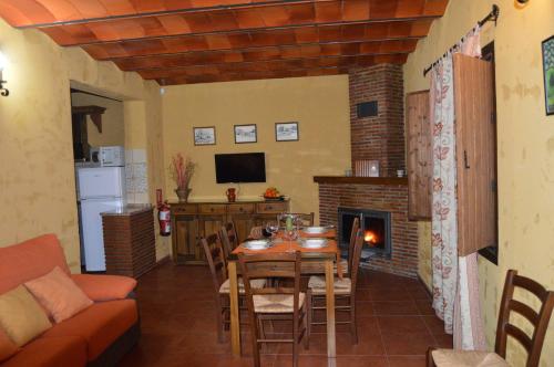 a kitchen and dining room with a table and a fireplace at Cortijo Molino los Justos in Fuentes de Cesna