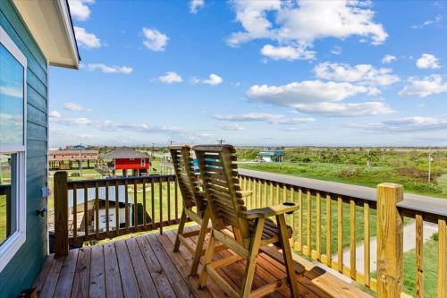 two chairs sitting on the deck of a house at Mimosa Beach - Luxury Beachfront 5BR, Gorgeous views from multiple Decks in Gilchrist
