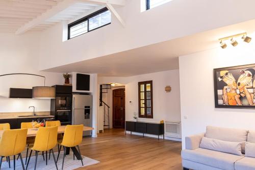 Il dispose d'une cuisine et d'un salon avec une table et des chaises jaunes. dans l'établissement Appartement centre Aix Terrace et ascenseur, à Aix-en-Provence