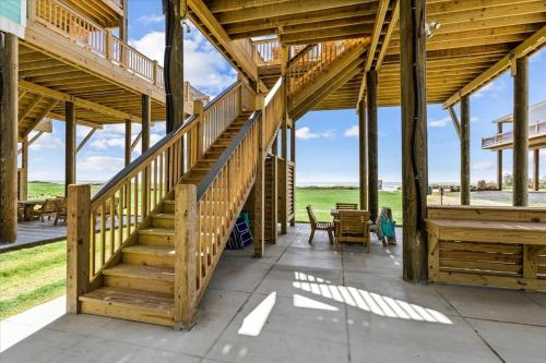 a large wooden building with stairs and a patio at Mimosa Beach - Luxury Beachfront 5BR, Gorgeous views from multiple Decks in Gilchrist