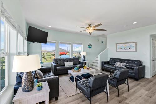 a living room with black furniture and a ceiling fan at Mimosa Beach - Luxury Beachfront 5BR, Gorgeous views from multiple Decks in Gilchrist