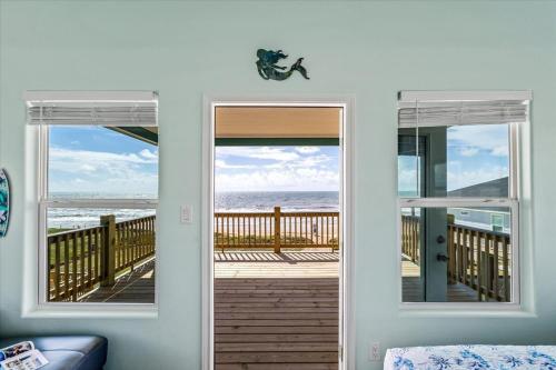 a room with a door open to the ocean at Mimosa Beach - Luxury Beachfront 5BR, Gorgeous views from multiple Decks in Gilchrist