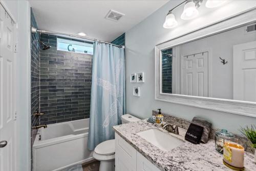 a bathroom with a sink and a toilet and a mirror at Mimosa Beach - Luxury Beachfront 5BR, Gorgeous views from multiple Decks in Gilchrist