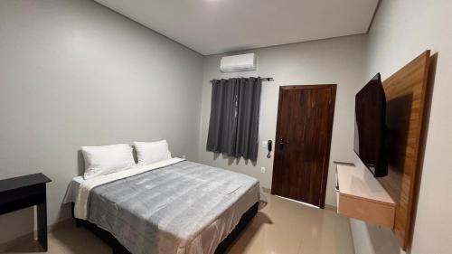a bedroom with a bed and a television in it at Hotel Pousada Prime in Campo Novo do Parecis