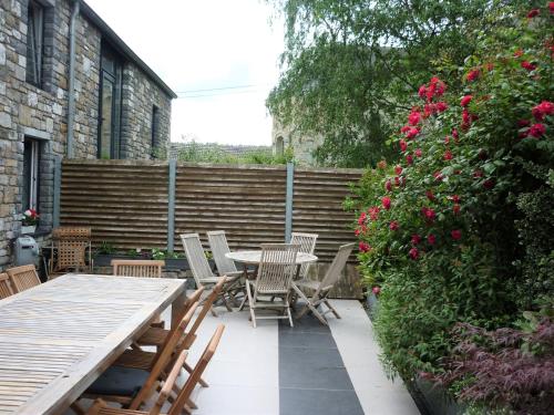 a patio with a table and chairs and flowers at Belgium your low-cost stays in luxury gites in Hamoir