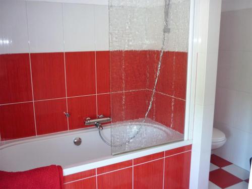 a red and white bathroom with a bath tub at Belgium your low-cost stays in luxury gites in Hamoir