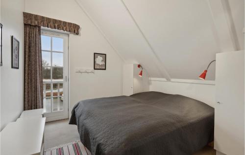 a white bedroom with a bed and a window at Two-Bedroom Apartment In Grasten in Gråsten