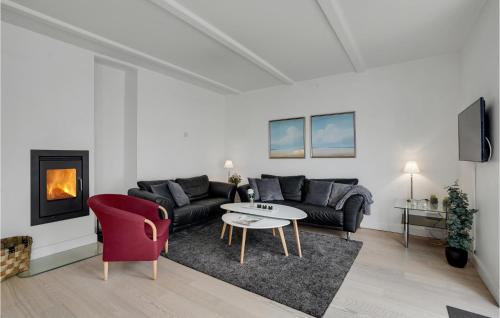 a living room with a couch and a table and a fireplace at Lovely Apartment In Gråsten With Sauna in Gråsten
