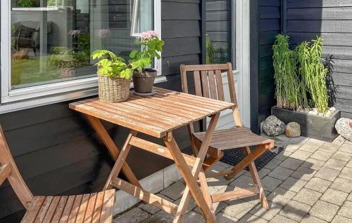 a wooden table and a chair on a patio at Cozy Home In Grenaa With Wifi in Grenå