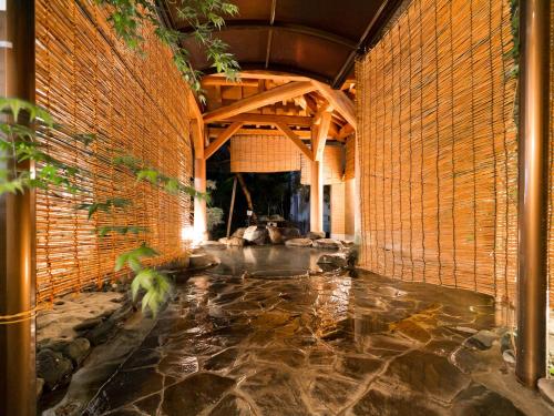 a room with a stone floor and a brick wall at 赤湯温泉 丹泉ホテル in Nanyo