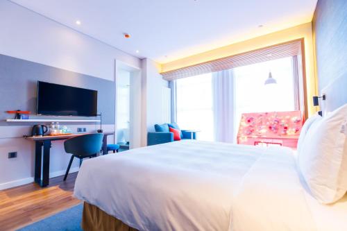 a hotel room with a large bed and a window at Holiday Inn Express Harbin Qunli by IHG in Harbin