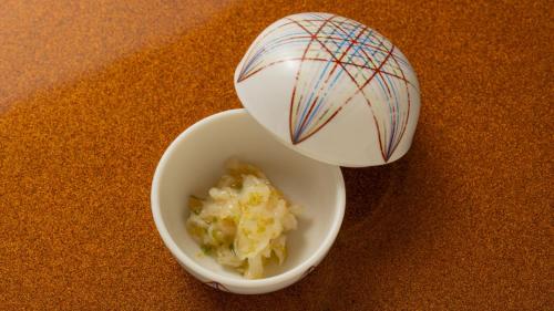 a container of food next to a bowl of food at Fujisan Ryokan in Hanamaki