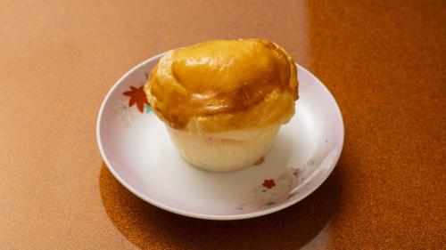 a cupcake on a white plate on a table at Fujisan Ryokan in Hanamaki