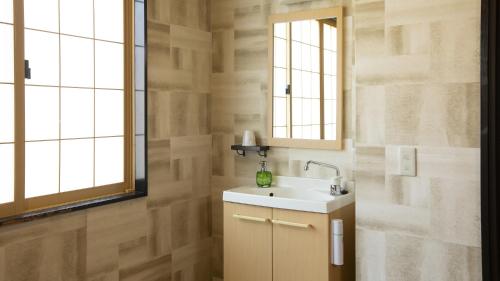 a bathroom with a sink and a mirror at Fujisan Ryokan in Hanamaki