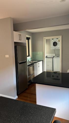 a kitchen with a black refrigerator and white cabinets at Charlestown TownHouse in Charlestown