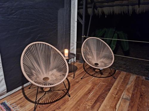 two white chairs and a table with a candle at Four Monkeys Eco Lodge - Jungle & Beach in Cabo Matapalo