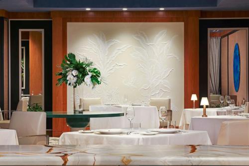 a dining room with white tables and white chairs at The Ritz-Carlton, Grand Cayman in George Town