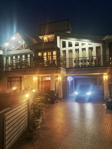 シロンにあるSamanbha Guest Houseの夜間の家の前に停車する車
