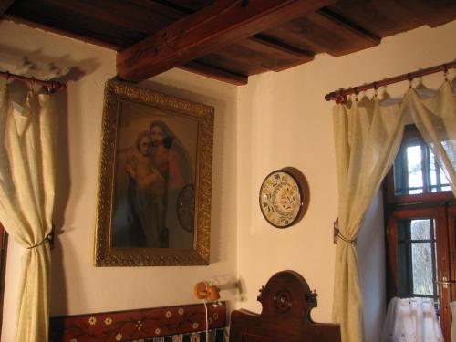 a painting of a couple on a wall next to a window at Cserépmadár szállás és Csinyálóház in Velemér