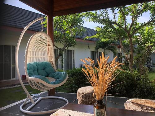 a wicker chair sitting on a patio at Amuya Home Stay in Waingapu
