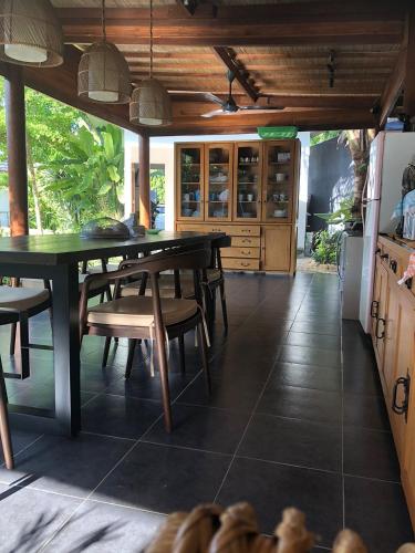 a kitchen with a dining room table and chairs at Amuya Home Stay in Waingapu