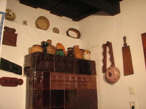 a bunch of pots and pans on top of a fireplace at Cserépmadár szállás és Csinyálóház in Velemér