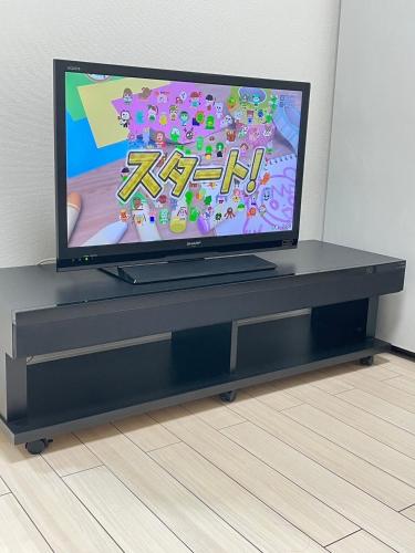 a flat screen tv sitting on a black entertainment center at 結奈希 Yunakis House in Tokyo