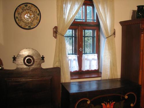 a room with a window and a table and a clock at Cserépmadár szállás és Csinyálóház in Velemér