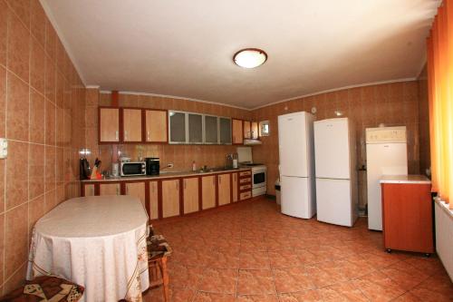 una cocina con 2 neveras y una mesa. en Vila Doina Branului, en Bran