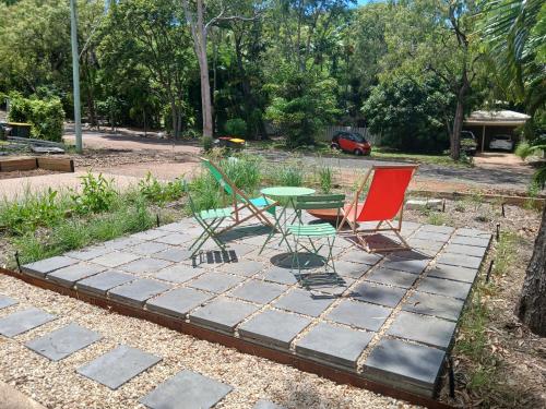 two chairs and a table on a stone patio at Rosalita, Picnic Bay in Picnic Bay