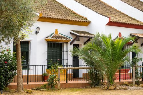 una casa blanca con una valla negra en Casa Rural Los Pinos, en Hinojos