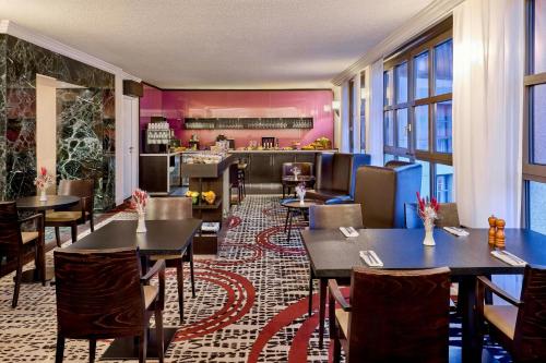 a restaurant with tables and chairs and a bar at Hamburg Marriott Hotel in Hamburg