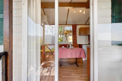 a kitchen and dining room with a table and a window at Camping Royal in Pettenasco