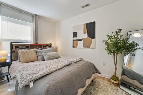 a bedroom with a bed and a potted plant at Modern Farmhouse w King Bed Near Shopping in Streamwood