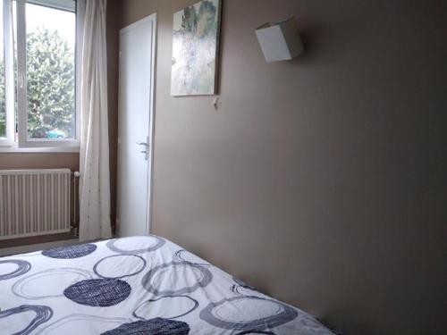 une chambre avec un lit dans une pièce avec une fenêtre dans l'établissement Proche du centre ville, à La Rochelle