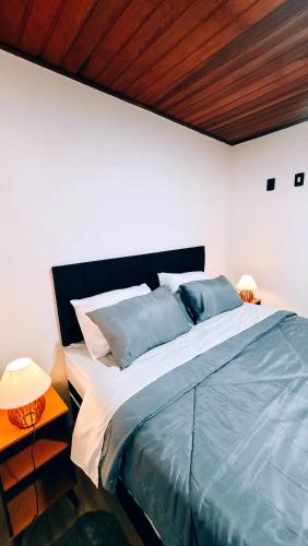 a bedroom with a large bed with a wooden ceiling at Cantinho Dona Cleide in Monte Verde