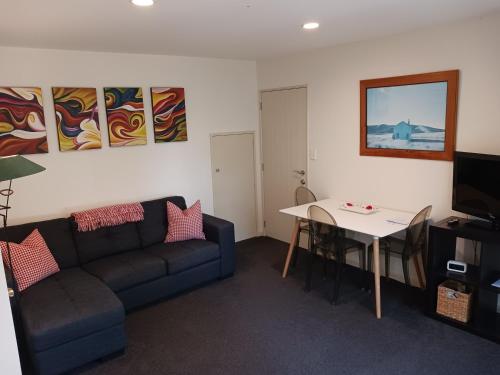 a living room with a couch and a table at Kingfisher Spacious Private Studio - Reserve & Wetlands in Mapua